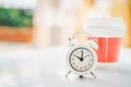White analog clock at ten o`clock and blurred plastic hot coffee cup on desk for coffee break with copy space Royalty Free Stock Photo