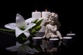 White angel with candles and white lily flower on a black background Royalty Free Stock Photo