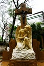 White angel statue kneeling on grave.