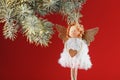 White angel toy on a Christmas tree on a red background. Free space Royalty Free Stock Photo