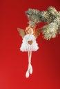 White angel toy on a Christmas tree on a red background Royalty Free Stock Photo