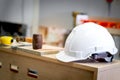 White antiknock safety helmet on wooden table at carpentry woodwork workshop Royalty Free Stock Photo