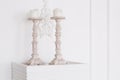 White antique candlesticks with candles close up. stucco wall