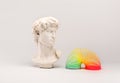 White antique plaster head with flower and Rainbow plastic multicolored spring spiral