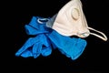 White antivirus mask and blue latex gloves on dark background Royalty Free Stock Photo