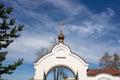 White arch with a dome and cross, entrance to the temple territory