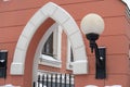 White arch in the red wall, fence and street lamp, snow Royalty Free Stock Photo