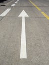 White arrow on the asphalt, broken white and yellow lines. Painted road marking markings. Road marking background. Traffic sign Royalty Free Stock Photo