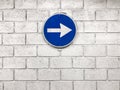 White arrow on blue road sign hanging on wall pointing right dir Royalty Free Stock Photo