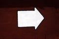 White arrow on dark red concrete wall Royalty Free Stock Photo