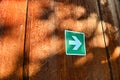 White arrow in green sign on rusty rough metal surface Royalty Free Stock Photo