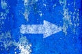 White arrow painted on old grunge and weathered blue wall texture background Royalty Free Stock Photo