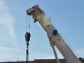 White arrow of a construction car crane against the blue sky