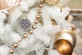 White artificial Christmas tree decorated with a silver cone, shiny balls and a golden garland. Festive New Year background Royalty Free Stock Photo