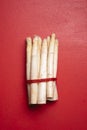 White asparagus on a red table, top view. Fresh vegetables