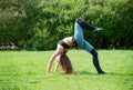 White athletic young woman in sportswear makes a bridge on the grass in the Park, yoga