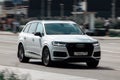 White Audi Q7 car moving on the street, front side view Royalty Free Stock Photo