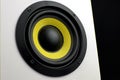 White audio speaker on a black background. Subwoofer, close-up. Minimalistic audio speaker with a yellow subwoofer Royalty Free Stock Photo