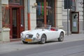 White auto MG cabriolet standing on curb of city road in Lodz