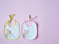 White baby bibs with pink and yellow border, on pink background Royalty Free Stock Photo