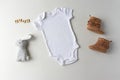 White Baby Bodysuit, Shoes, Toy & Letters - Baby One Piece Mockup Royalty Free Stock Photo