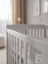 White baby crib in a bright, modern nursery room. Royalty Free Stock Photo