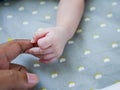 White baby holding finger of black adult hand Royalty Free Stock Photo