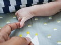 White baby holding finger of black adult hand Royalty Free Stock Photo