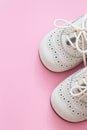 White baby shoes on pink background