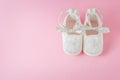 White baby shoes on pink background Royalty Free Stock Photo