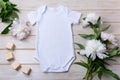 White baby short sleeve bodysuit mockup with peony and toy blocks