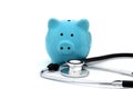 On a white background is a blue piggy bank and a stethoscope. Royalty Free Stock Photo