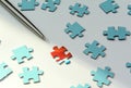 On a white background blue puzzles. A silver puzzle points to a red puzzle