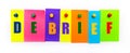 On a white background, buttons are used to fix bright multi-colored strips of paper with the text DEBRIEF Royalty Free Stock Photo