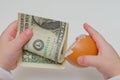 Child took a dollar in an egg shell on white background Royalty Free Stock Photo