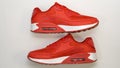 On a white background, close-up, red sports sneakers, with white sole, there is a shadow