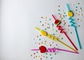 On a white background are colored twisted cocktail tubes with plastic berries