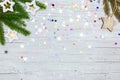 White background with colorful festive confetti, christmas tree branch and glowing lights Royalty Free Stock Photo