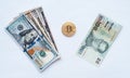 On a white background, exchange of Thai baht for us dollars on a metal coin bitcoin in paper money from crypto currency. Royalty Free Stock Photo