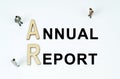 On a white background, figures of businessmen, wooden letters and the inscription - ANNUAL REPORT