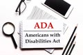 On a white background glasses, a magnifier, pencils, a smartphone and a notebook with the text ADA Americans with Disabilities Act Royalty Free Stock Photo