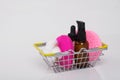 On a white background, in an iron basket, there are massage oil and sponges for cleaning the face