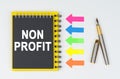 On a white background lies a pen, arrows and a notebook with the inscription - NON PROFIT