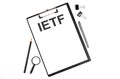 On a white background magnifier, a pen and a sheet of paper with the text IETF - Internet Engineering Task Force . Business Royalty Free Stock Photo