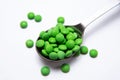 A lot of green pills in a metal teaspoon Royalty Free Stock Photo