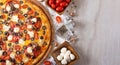 On a white background pizza on a wooden plate. Top it is decorated with tomatoes, olives and mozzarella cheese. Tomatoes and Royalty Free Stock Photo