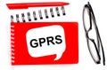 On a white background, white and red notepads, black glasses, a red pen and a white card with the text GPRS General Packet Radio
