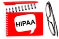 On a white background, white and red notepads, black glasses, a red pen and a white card with the text HIPAA The Health Insurance Royalty Free Stock Photo