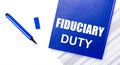 On a white background reports, a blue pen and a blue notebook with the text FIDUCIARY DUTY. Business concept. Banner