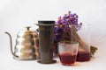 White background, strong, morning, specialty coffee brewed by an alternative method from gadget. Bouquet of field flowers and glas